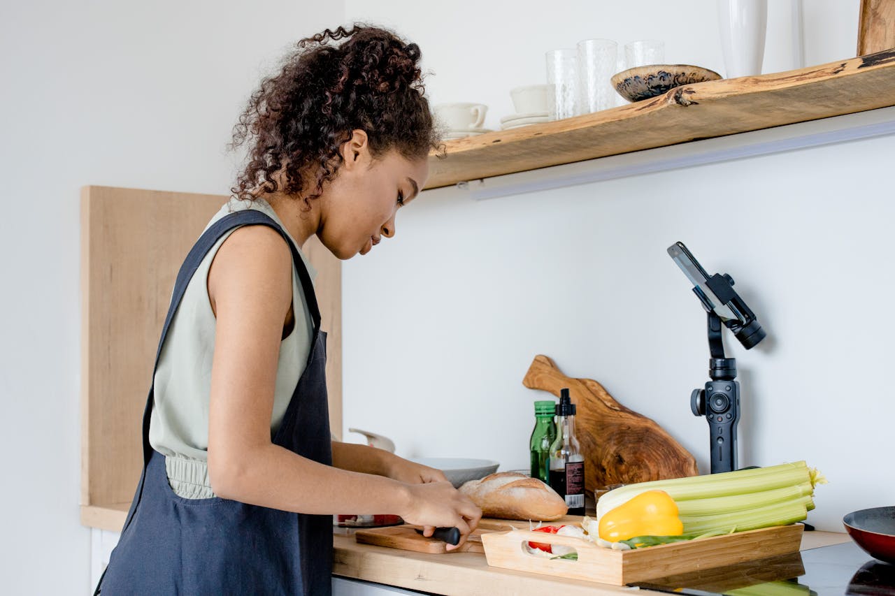 Side view of a woman cooking in a modern kitchen, captured for a cooking vlog.