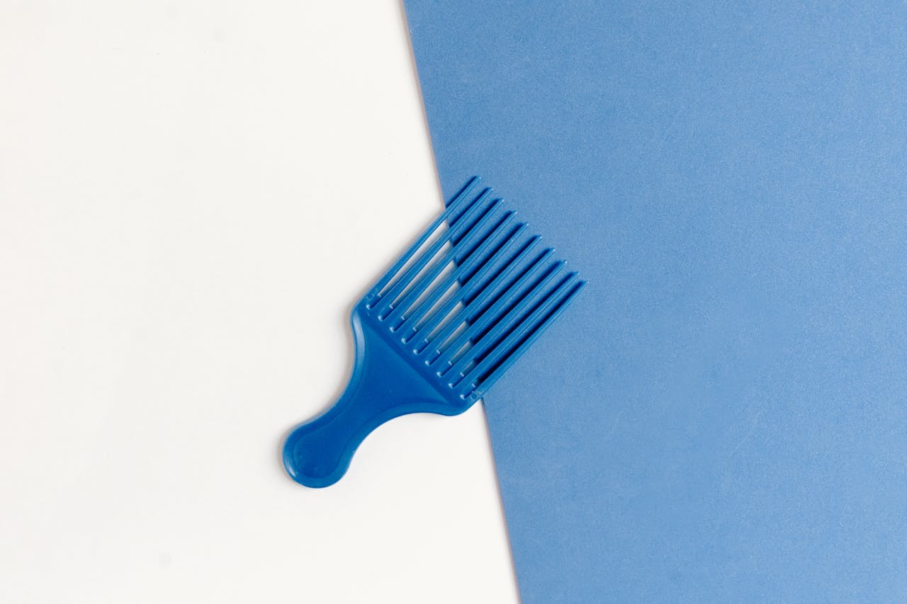 services-04 Stylish blue plastic comb on a dual-tone white and blue background.